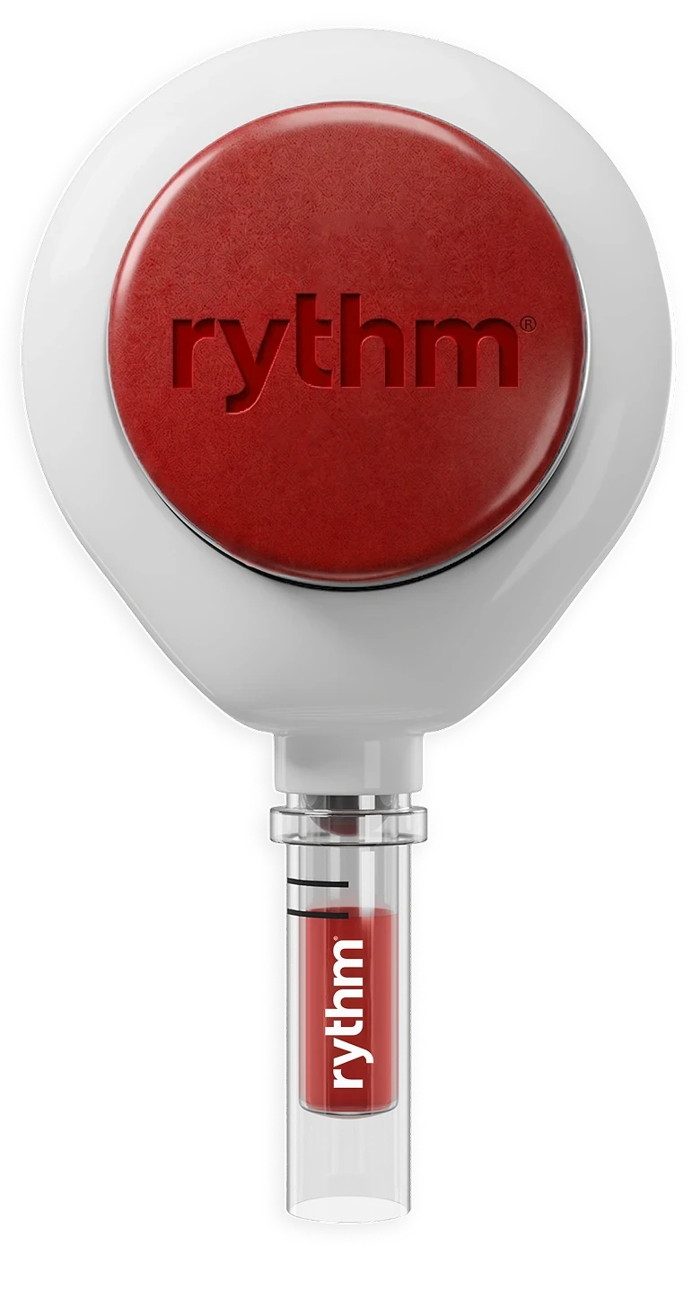 The Rythm at-home blood collection device: a white housing with a red button on top and a small collection tube below